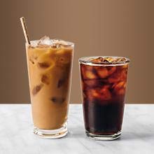    Two cups of ice coffee, with the left one containing milk, and the right one is dark brown
